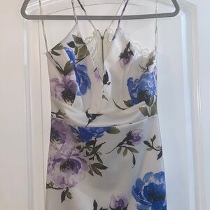 It’s a white dress with blue and purple flowers with a lace detail on the back